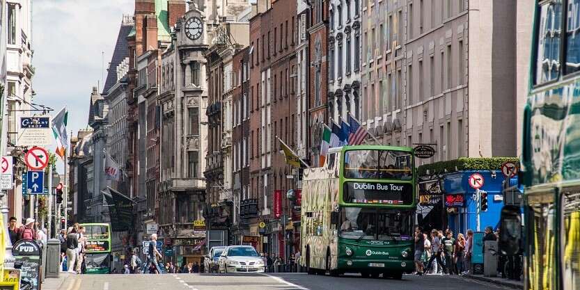 Busy streets of dublin with lot of commuters crossing the road 