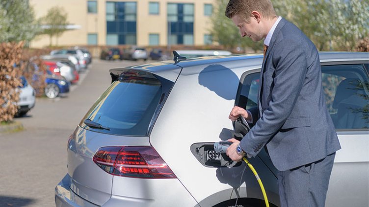 Man inserting an EV charger into an electric vehicle
